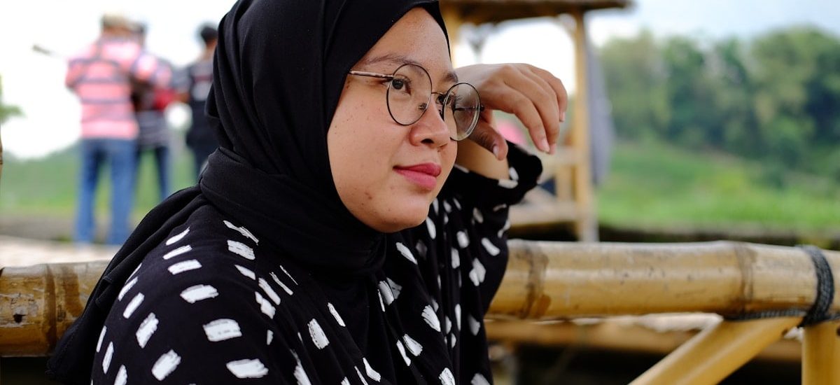 a woman in a black and white top and glasses